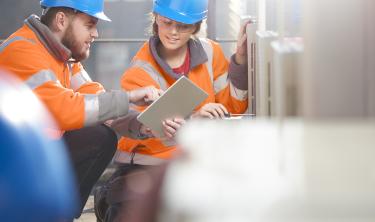 Ouvriers travaillent sur un chantier avec une tablette